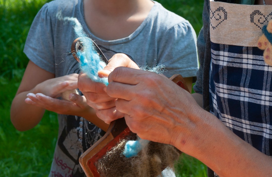 Hände kneten eine weiße Masse aus Wolle und Seife